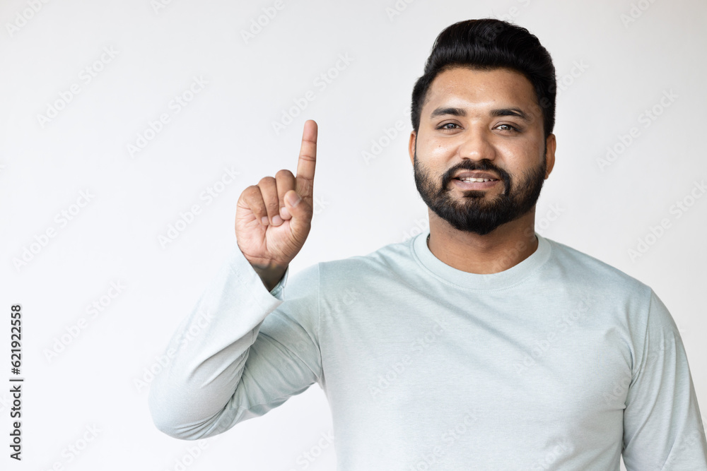 Confident Happy Smiling South Asian Man Pointing Up one finger Gesture for Success, Goal, Direction concept on Isolated Background Confident Happy Smiling South Asian Man Pointing Up one finger Gesture for Success, Goal, Direction concept on Isolated Background