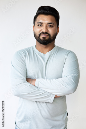 Confident and Happy South Asian Man with Crossed Arms on Isolated Background