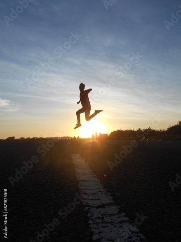 silhouette of a person running on the road