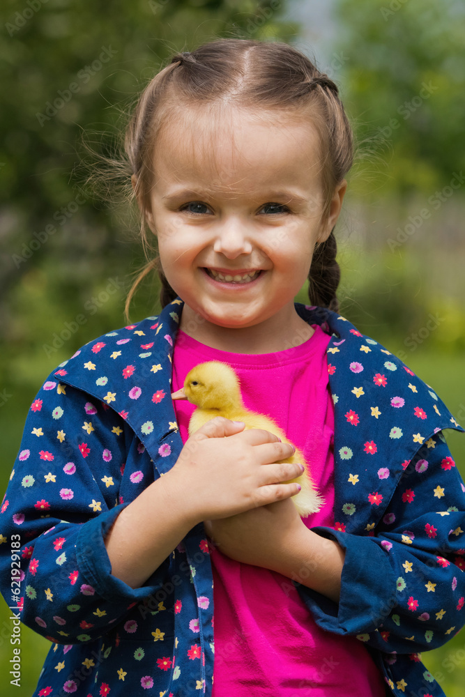Cute happy little girl with of small duckling in the garden. Little girl holding a duckling in her hands. Cute happy little girl with of small duckling in the garden. Little girl holding a duckling in her hands.
