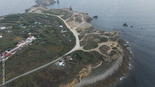 Aerial view of houses along the coastline in Peniche at sunset with Berlengas Islands in background, Leiria district, Portugal. photo