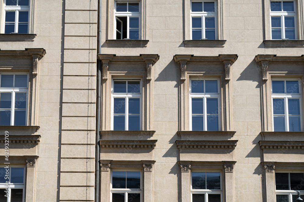 Facade of old tenement houses in Poland. Historical old town residential architecture. Building windows.