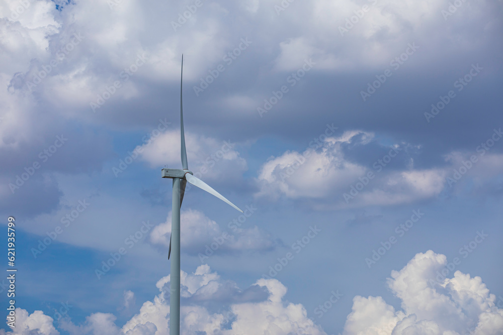 Wind turbine on the brown grass over mountain the blue Wind turbine on the brown grass over mountain the blue
