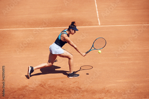 Top view image of young girl, professional tennis player in motion during game at open air tennis court on sunny day. Concept of sport, hobby, active lifestyle, health, endurance and strength, ad © master1305