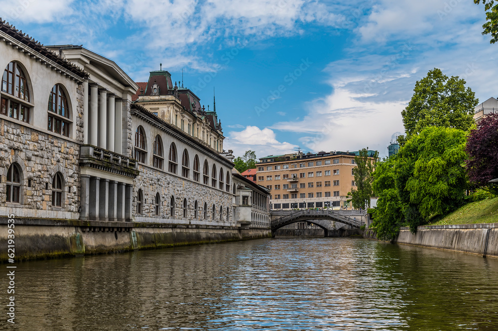 A view along the Ljubljanica River past the market towards the Triple Bridge in Ljubljana, Slovenia in summertime A view along the Ljubljanica River past the market towards the Triple Bridge in Ljubljana, Slovenia in summertime