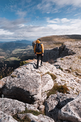 young mountaineer man walks on the rocks through the spectacular landscape of the mountains of gorobel or sierra salbada in Alava Basque Country photo