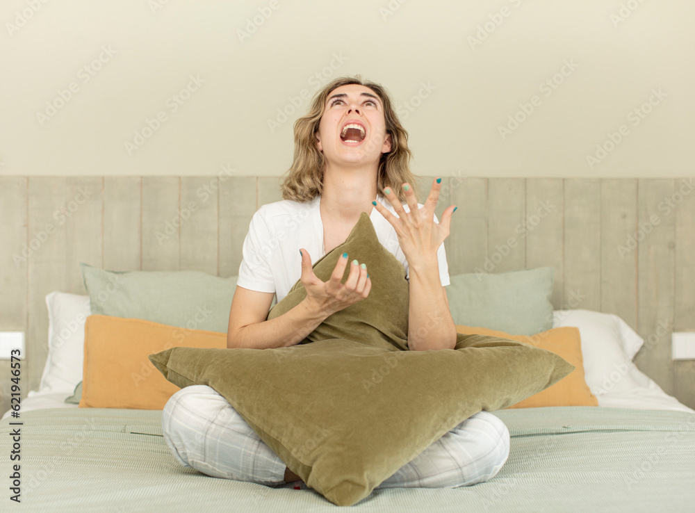 pretty woman screaming with hands up in the air. nightwear and bedroom concept pretty woman screaming with hands up in the air. nightwear and bedroom concept