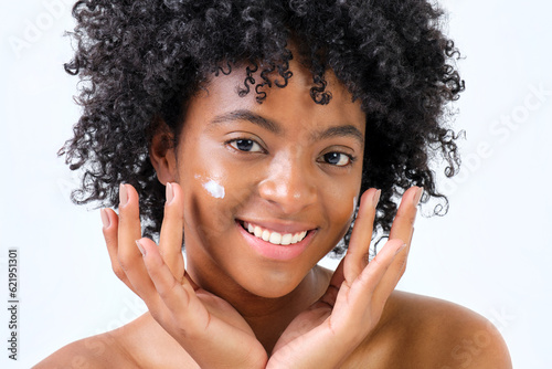 young african american girl smiling giving cream on her face with hands on white background