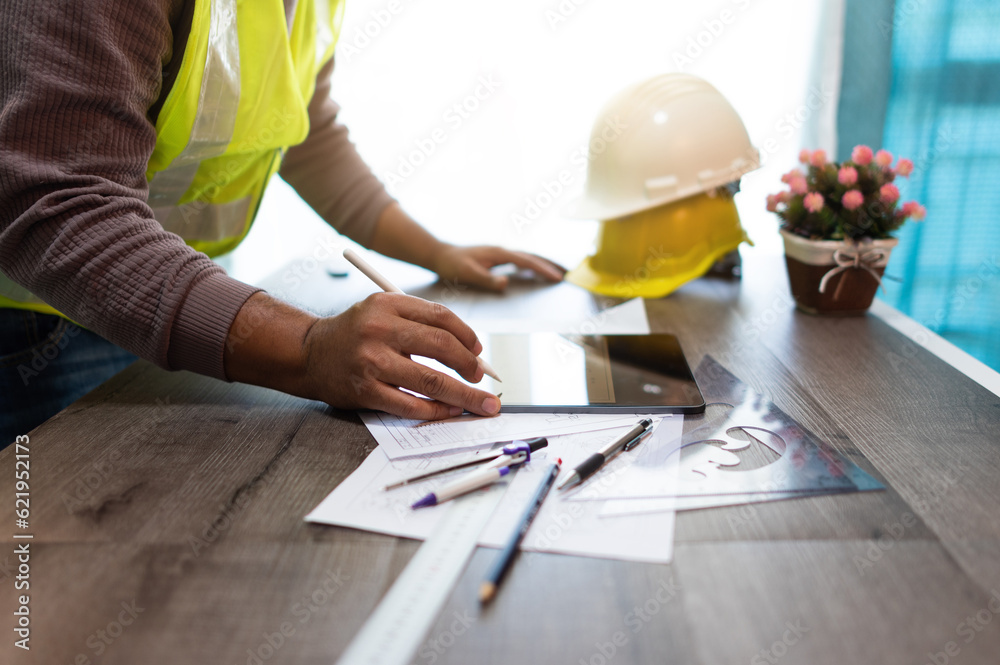 An electrical engineer, he's planning and checking drawings on his tablet. An electrical engineer, he's planning and checking drawings on his tablet.