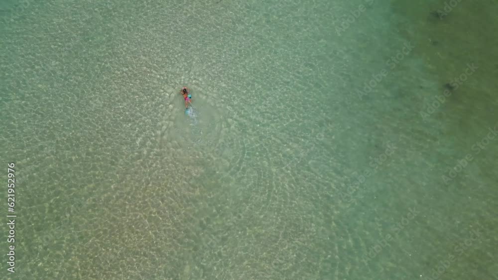 Aerial view of person snorkelling and swimming in transparent sea on Sairee beach on Ko Tao island, Thailand. Aerial view of person snorkelling and swimming in transparent sea on Sairee beach on Ko Tao island, Thailand.