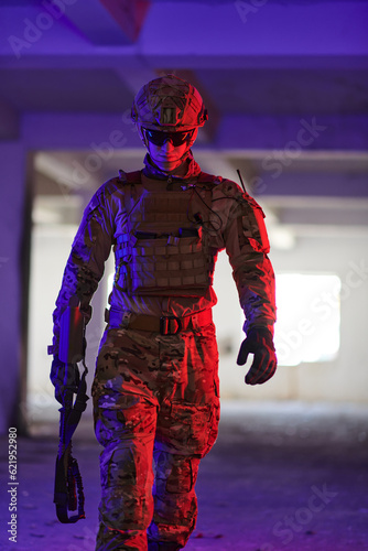 A professional soldier undertakes a perilous mission in an abandoned building illuminated by neon blue and purple lights © .shock