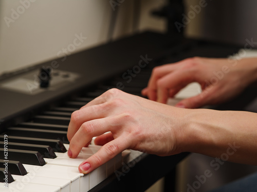 Musician's hands on the keys of a midi keyboard. Close-up. Music, melody, recording studio. Advertising, billboard.