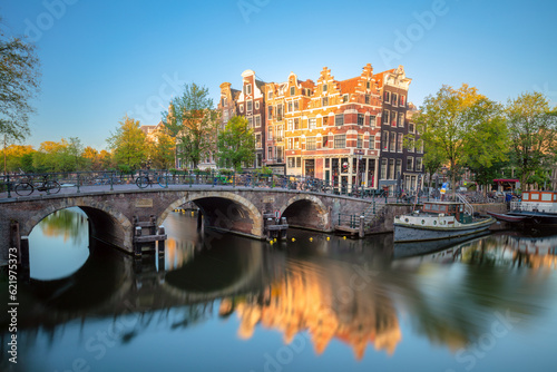 Early quiet morning in Amsterdam. Gentle sun shines the famous view of Amsterdam. Typical old houses and bridges.