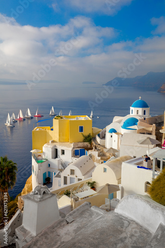 The famous view of the sights of Santorini - white houses, blue domes and yachts in the azure sea. Santorini island, Greece, Europe.