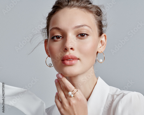 Close up portrait of a beautiful elegant woman with stylish jewelry on a white background. Beautiful girl with jewelry.