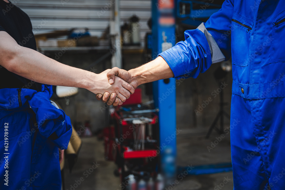 Auto mechanic handshake showing success collaboration of mechanics Check and maintain the engine for customers. Auto mechanic handshake showing success collaboration of mechanics Check and maintain the engine for customers.