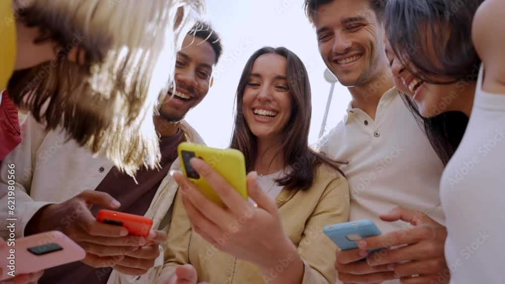 Caucasian girl looking at happy cell phone. Low angle view of group friends addicted to technology. People gathered in circle using mobile. New generations and communication through social networks.