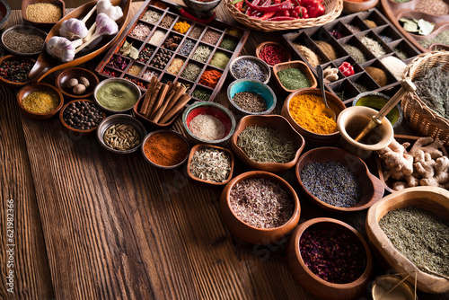 Spices. Collection of spices in bowls on wooden rustic table forming an abstract background.