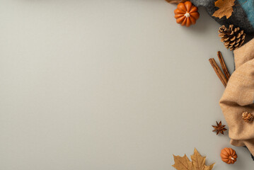 Experience the cozy bliss of autumn at home with this above view photo of patchy scarf, pumpkin candles, maple foliage, chinese anise with cinnamon set the scene for text or advert on grey background