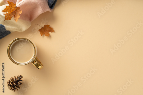 Experience the feeling of warming up in fall season with warm patchy plaid and a cup of hot cacao drink and maple leaves around on this high angle photo on beige isolated backdrop with copy-space