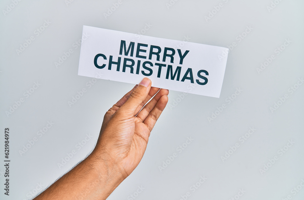 Hand of caucasian man holding paper with merry christmas message over isolated white background Hand of caucasian man holding paper with merry christmas message over isolated white background