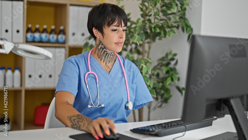 Hispanic woman with amputee arm doctor using computer working at clinic