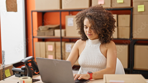 Young beautiful hispanic woman ecommerce business worker using laptop working at office