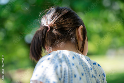 新緑の公園で遊ぶ5歳の女の子