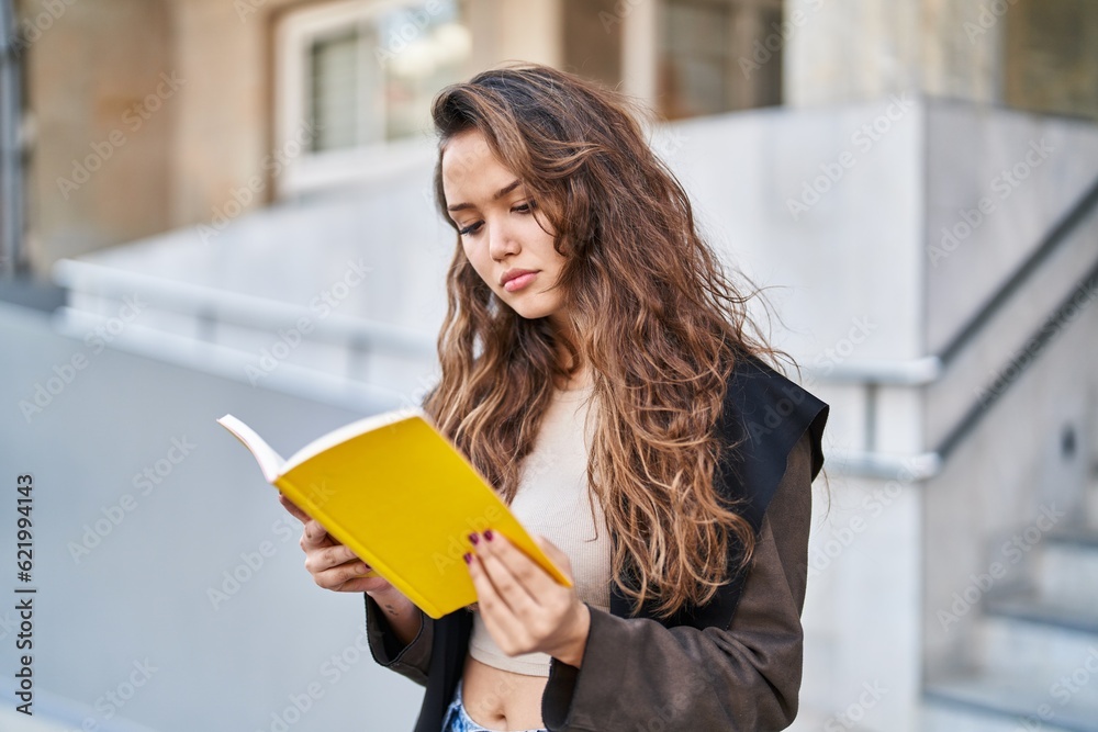 Young beautiful hispanic woman reading book at street Young beautiful hispanic woman reading book at street