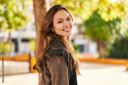 Young beautiful hispanic woman florist smiling confident using smartphone at park