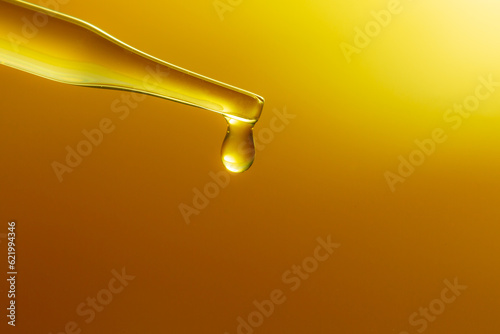 Yellow science test tube,Dropping yellow chemical liquid or essential oil to test tube on white background, lab research and development concept