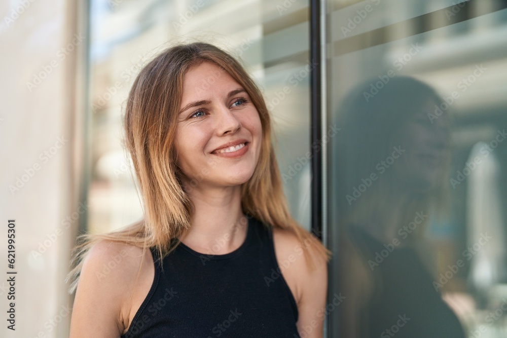 Young blonde woman smiling confident looking to the side at street Young blonde woman smiling confident looking to the side at street