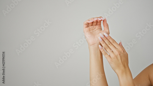 Young blonde woman massaging hands over isolated white background