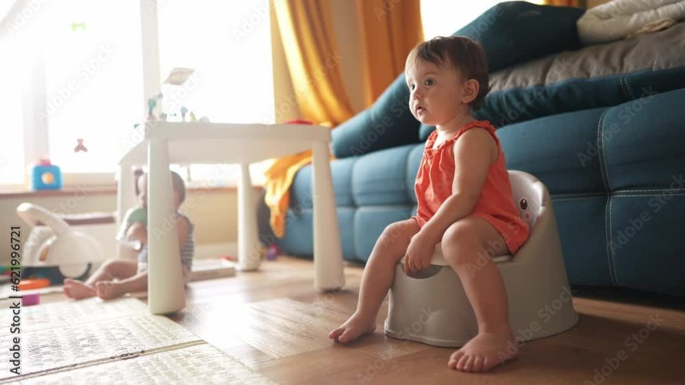 baby sitting on the potty. Toddler baby girl goes to the toilet sits on