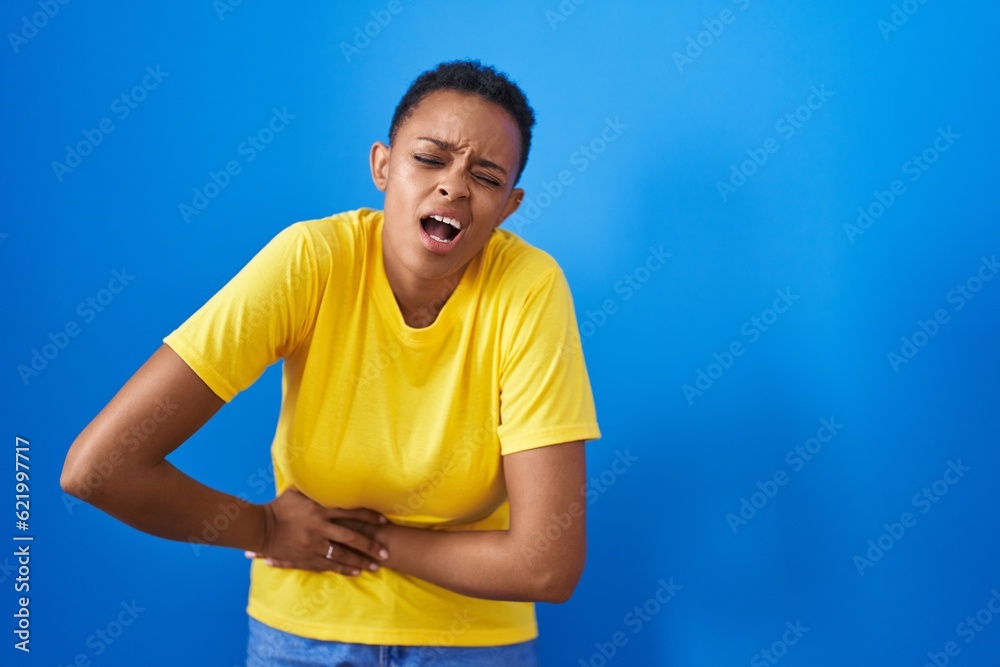 African american woman suffering for stomach ache standing over isolated blue background