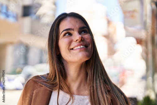 Young beautiful hispanic woman smiling confident looking to the sky at street © Krakenimages.com