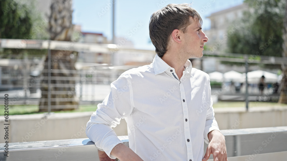 Young caucasian man looking to the side with serious expression at street Young caucasian man looking to the side with serious expression at street