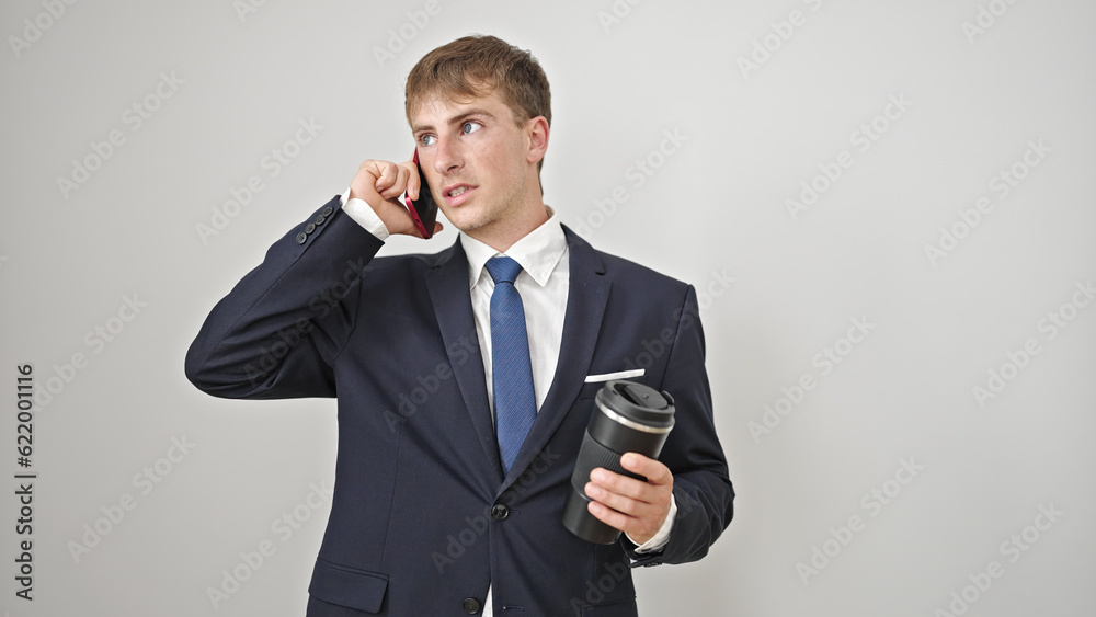 Young caucasian man business worker talking on smartphone holding coffee over isolated white background