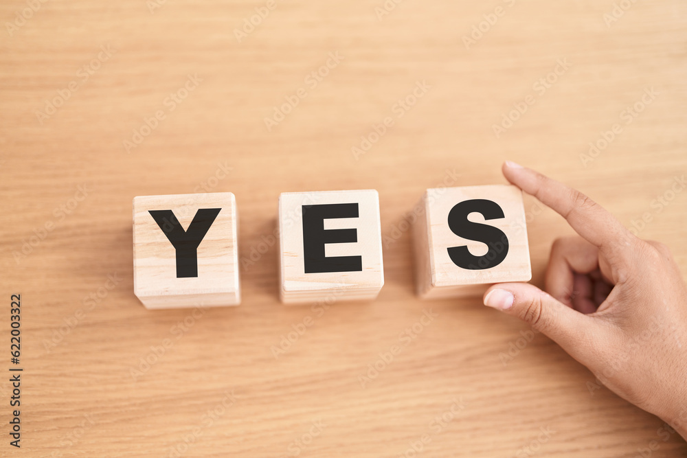Woman hand holding cubes with yes word on the table Woman hand holding cubes with yes word on the table