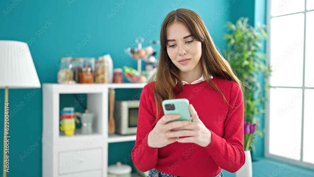 Young hispanic woman using smartphone standing at dinning room Young hispanic woman using smartphone standing at dinning room