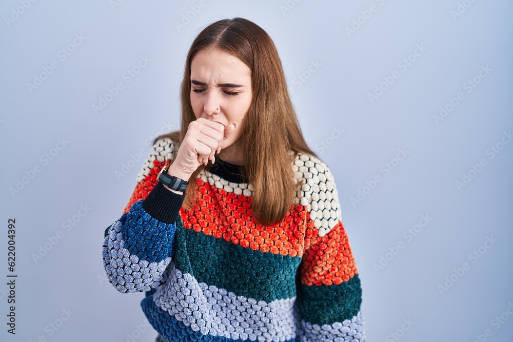 Young hispanic girl standing over blue background feeling unwell and coughing as symptom for cold or bronchitis. health care concept. Young hispanic girl standing over blue background feeling unwell and coughing as symptom for cold or bronchitis. health care concept.