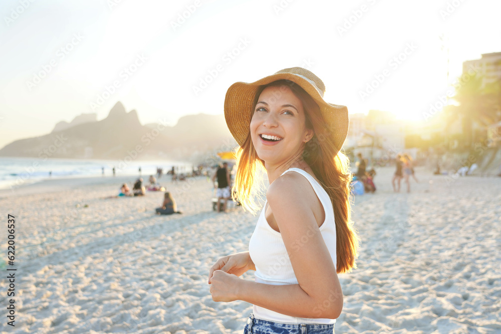 Healthy beautiful young woman smiling on Ipanema beach. Delightful laughing  girl enjoying sunset in Rio de Janeiro, Brazil.