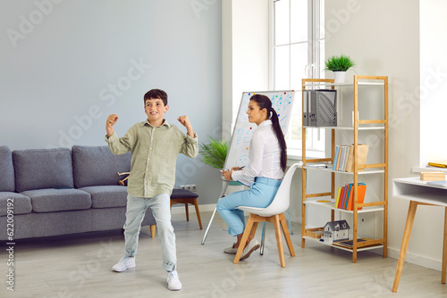 ADHD child at therapist's office. Naugty unruly hyperactive agitated aggressive school bully boy acts up, misbehaves, causes trouble at session with psychologist. Hyperactivity, bad behavior concept photo