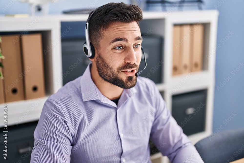 Fototapeta premium Young hispanic man call center agent working at office