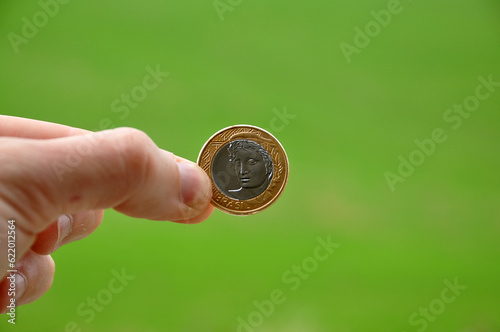 mão segurando moeda, conceito de ecônomia financeira no brasil  photo