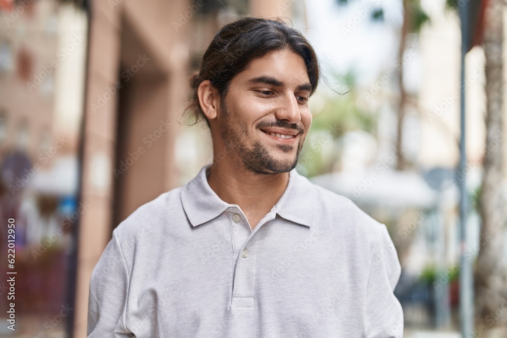 Young hispanic man smiling confident looking to the side at street Young hispanic man smiling confident looking to the side at street