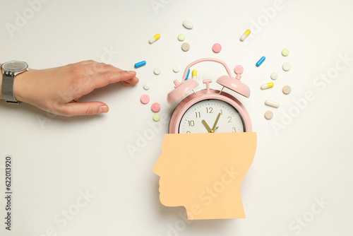 Pink alarm clock from a paper head on a light background