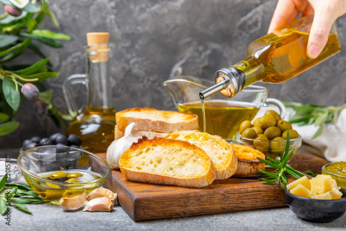 Fotografija Bruschetta with olive oil, olives, pesto, garlic and parmesan