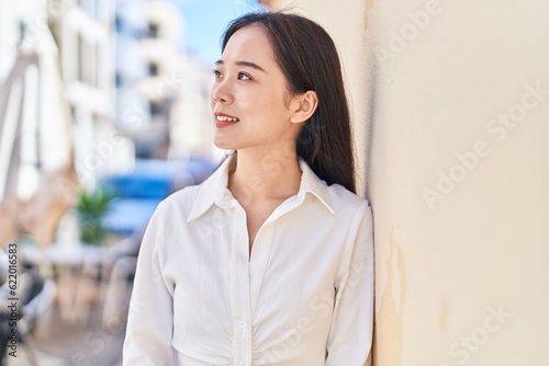 Obraz na plátně Young chinese woman smiling confident looking to the side at street