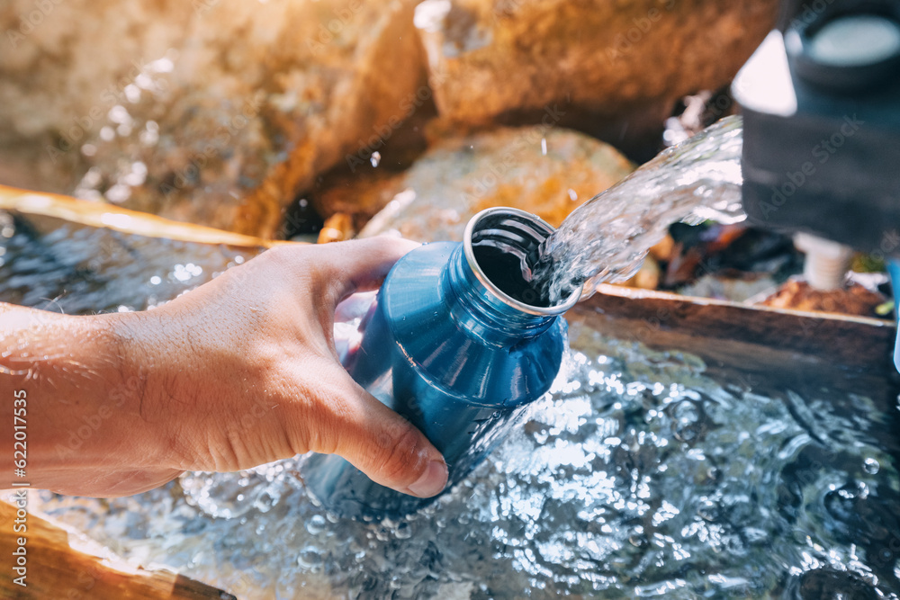 Pouring water from a spring source at camping or hiking. Clean looking water can be contaminated and dangerous to health